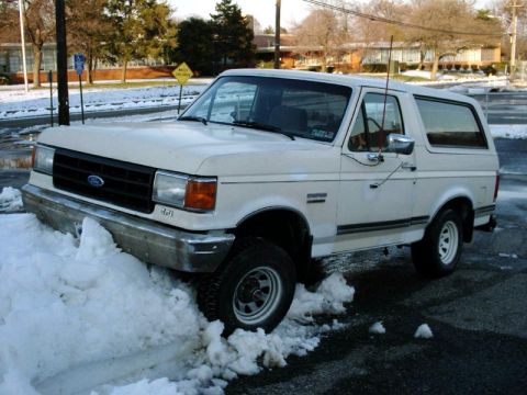 1988 Ford Bronco - White Ford Bronco stuck in snow on a winter day.