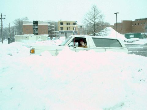 1988 Ford Bronco - A person in a white SUV gives a thumbs up while stuck in a large snowdrift.