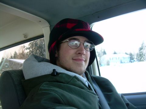 1988 Ford Bronco - A man in a plaid hat and glasses smiles from the interior of a 1988 Ford Bronco on a snowy day.