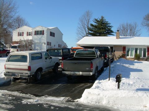 1988 Ford Bronco - Several vehicles, including a 1997 Ford F-150 and a Ford Bronco, are parked in a driveway covered in snow.