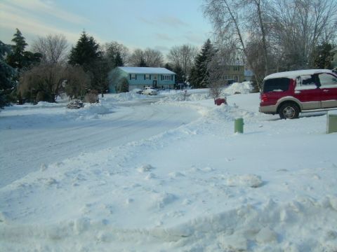 1988 Ford Bronco - A red SUV is parked on a snow-covered street during winter.