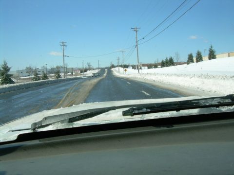 1988 Ford Bronco - Driving on a snowy road with a clear blue sky overhead.