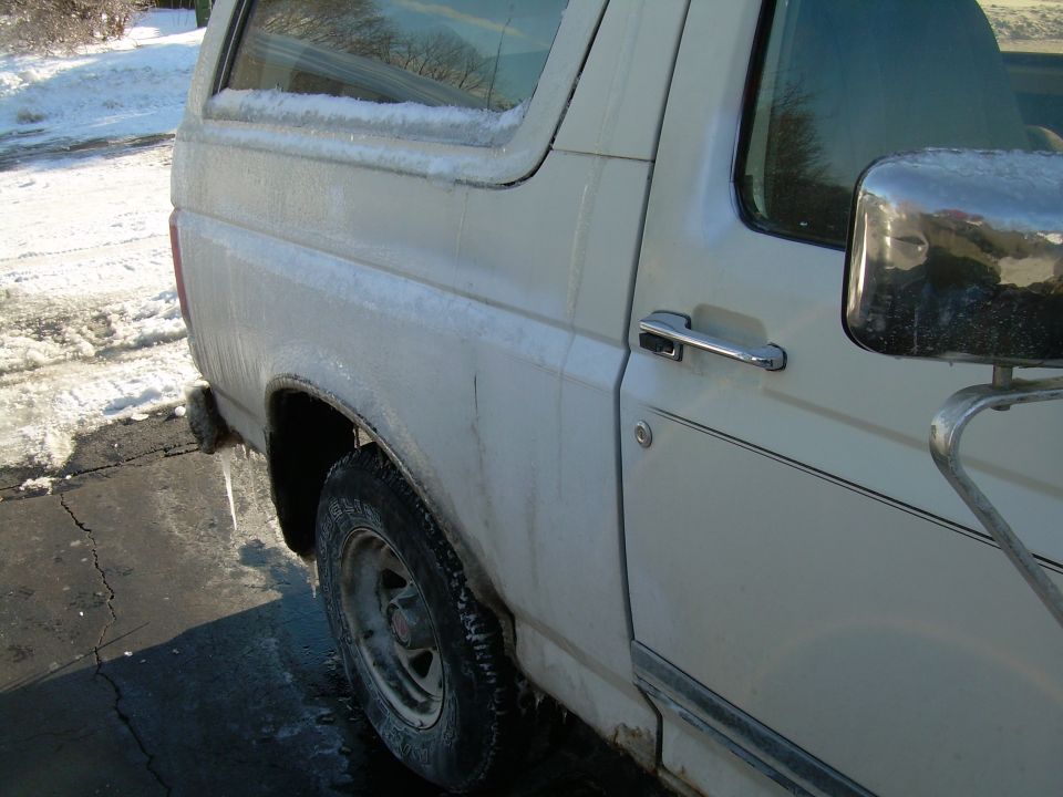 1988 Ford Bronco side view, covered in ice with icicles hanging from the rear bumper