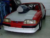 1990 Ford Mustang - Front view of a 1990 Ford Mustang modified for drag racing, a prominent hood scoop and roll cage.