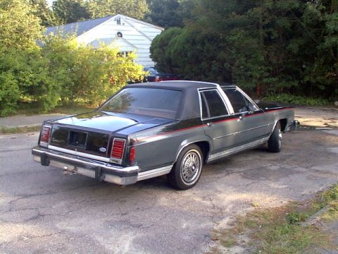 1987 Ford Crown Victoria LTD - This 1987 Ford Crown Victoria LTD is viewed from its rear-right quarter, showing its two-tone paint scheme and chrome trim.