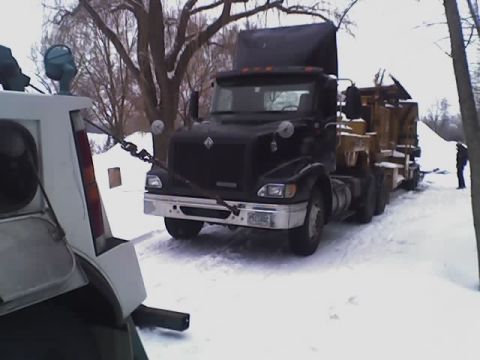 1992 Ford Bronco - A tow truck is pulling a semi-trailer truck through a snowy landscape.