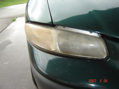 1997 Dodge Grand Caravan - Close-up of a discolored and damaged minivan headlight.