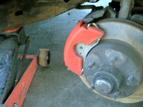 1976 Ford Ranchero - Close-up view of a vehicle's brake system, showing the caliper and rotor.