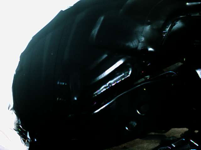 close-up of a dark vehicle wheel well with suspension parts visible