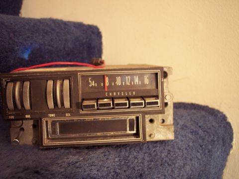 1968 Chrysler Town & Country - A vintage Chrysler car radio is shown, multiple knobs and push-button controls for audio functions.