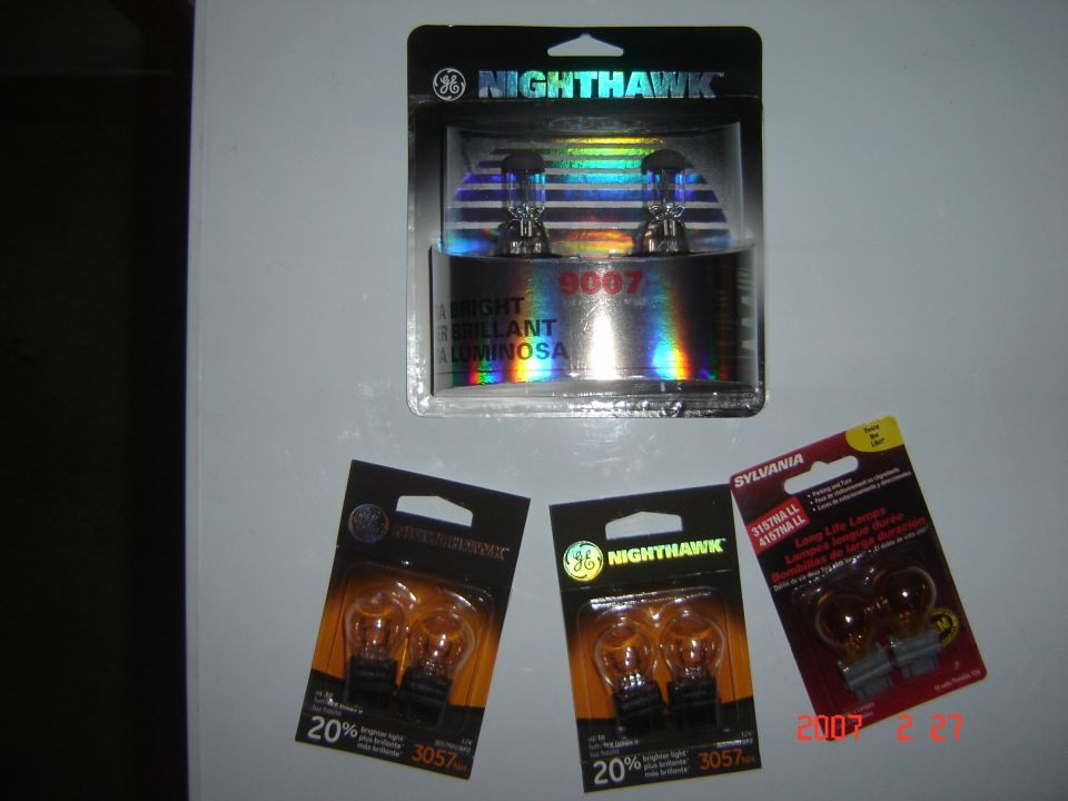 GE Nighthawk 9007 headlight and 3057 bulb packs with Sylvania amber lamps on white surface