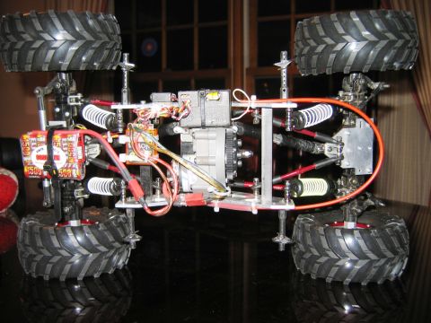 1985 Ford Bronco - The chassis of a remote control truck is shown from a low angle, revealing its mechanical components.