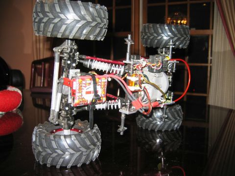 1985 Ford Bronco - This RC truck chassis features large off-road tires and visible electronic components, including a battery pack.