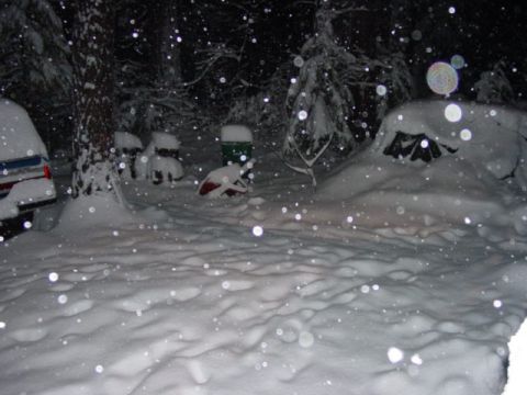 1986 Ford Bronco - A snowy night scene with multiple vehicles and a tent covered in thick snow.