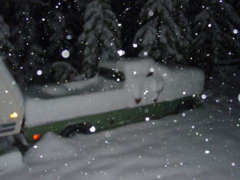 1986 Ford Bronco - Truck buried in snow during a winter storm at night.