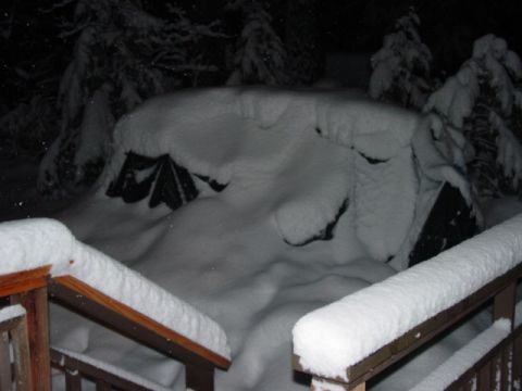 1986 Ford Bronco - A vehicle is completely covered in a thick blanket of snow during a winter storm.
