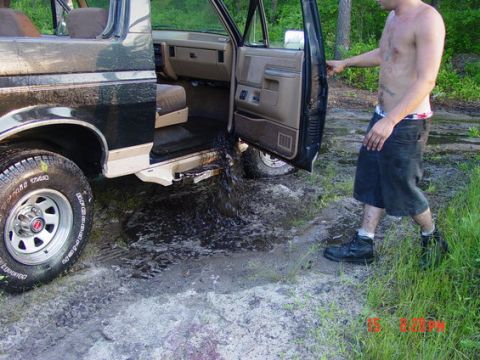 1987 Suzuki Samurai - Water drains from the interior of a Ford Bronco II after being driven through mud.