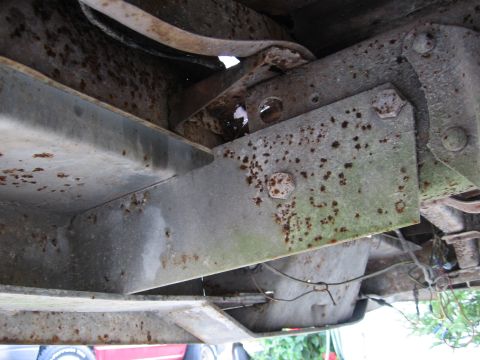 1974 Ford F-100 - Underside view of heavily rusted frame and fuel tank, showing wear and tear.