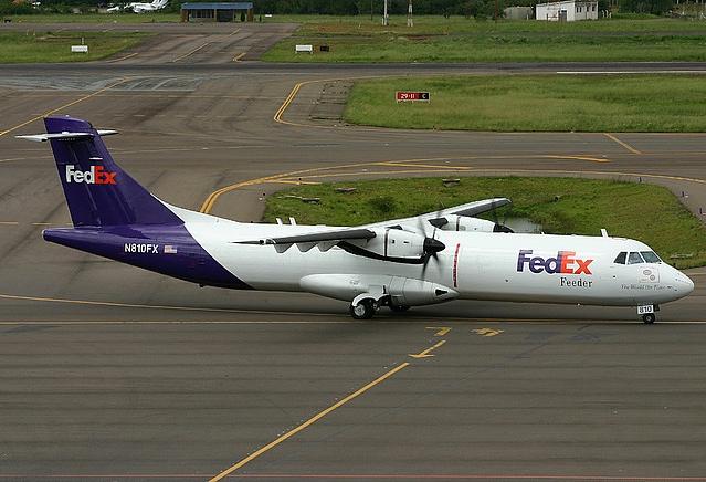 White FedEx Feeder turboprop plane with purple tail, registration N810FX, on an airport taxiway