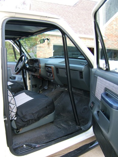 1991 Ford Bronco - The interior of a 1991 Ford Bronco shows a roll cage and a custom seat cover.