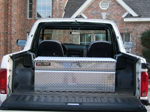 1991 Ford Bronco - The rear view of a white 1991 Ford Bronco shows a diamond plate toolbox secured in the bed.