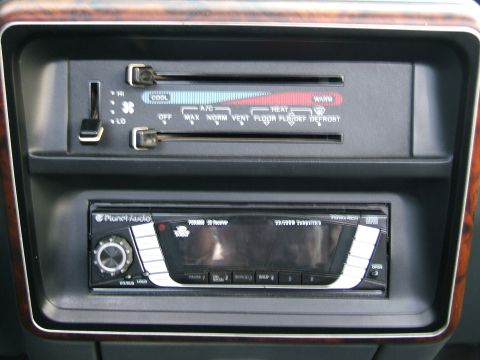 1991 Ford Bronco - The dashboard features climate controls with temperature and fan speed settings, alongside an aftermarket stereo unit.
