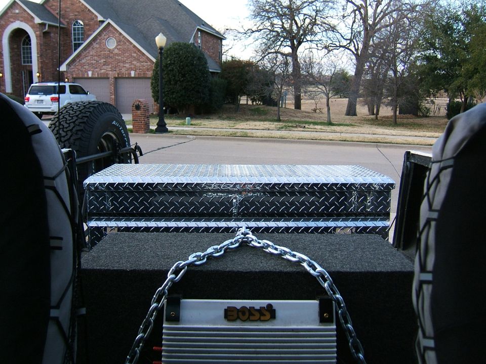Interior view of vehicle with toolbox, chain, and BOSS amplifier
