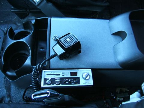 1991 Ford Bronco - A CB radio and microphone are visible inside a vehicle's cabin, mounted on the center console.