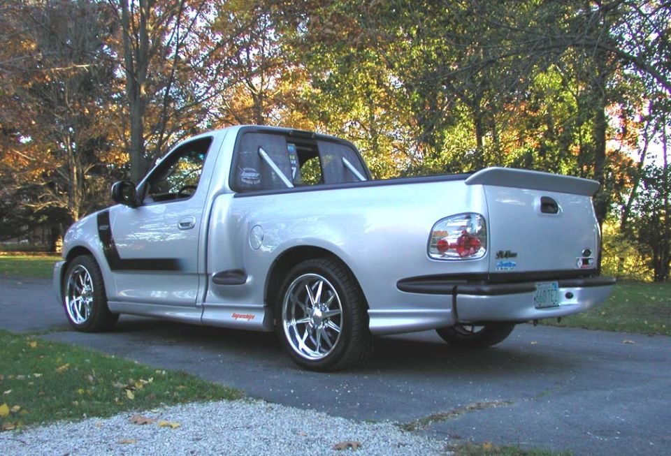 Silver 2001 Ford F-150 Lightning pickup truck, rear 3/4 view