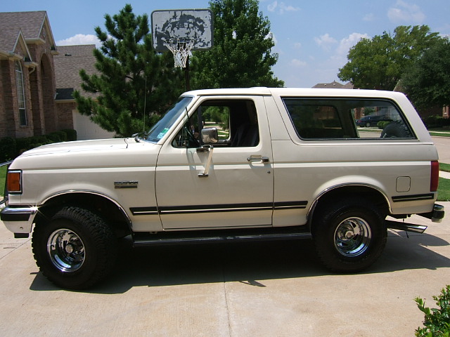 White 1991 Ford Bronco parked on a driveway, side view