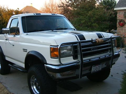 1991 Ford Bronco - This 1991 Ford Bronco is seen from a three-quarter front angle, equipped with a bull bar and racing stripes.