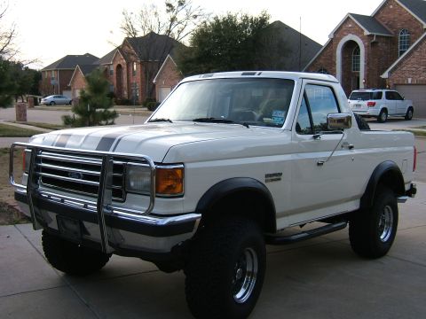 1991 Ford Bronco - White 1991 Ford Bronco parked in a driveway with houses in the background.