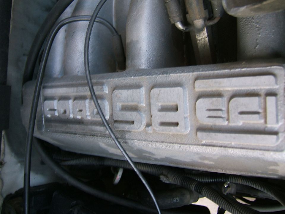 Close-up of a Ford 5.8 EFI intake manifold. Some wires and hoses are visible