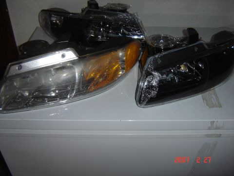 1997 Dodge Grand Caravan - Pair of aftermarket headlights, one clear and amber, the other blacked out.