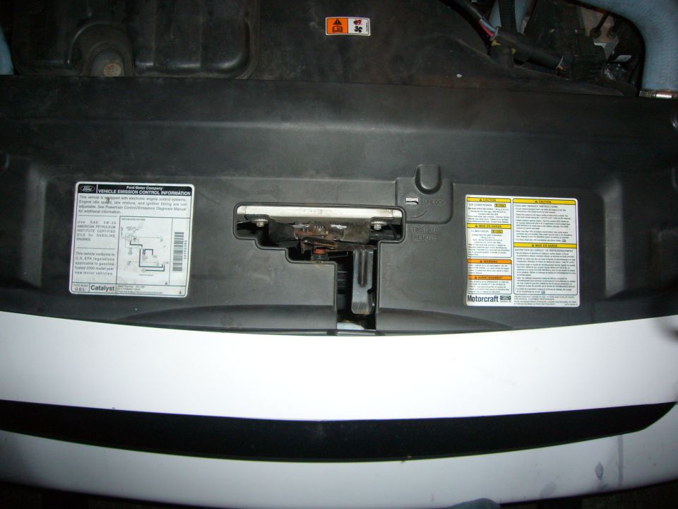 White car's engine bay with emission control information stickers