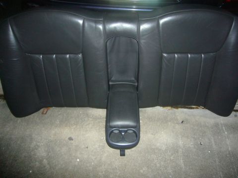 2000 Ford Crown Victoria - The black leather rear seat features a fold-down center console with two cup holders.