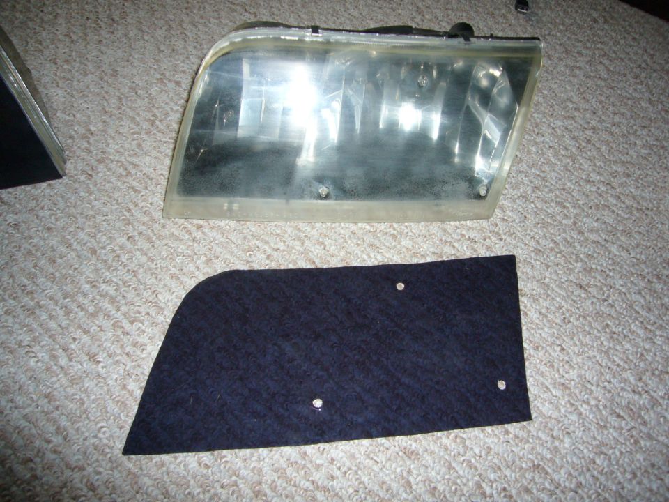 Car headlight assembly and a dark fabric trim piece with two screw holes