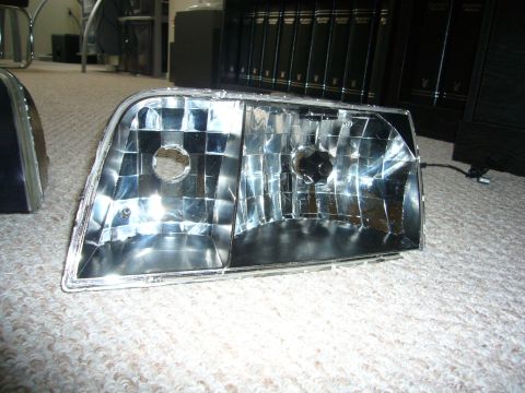 2000 Ford Crown Victoria - A single headlight assembly is shown in detail against a carpeted floor.