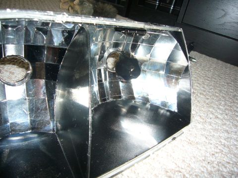 2000 Ford Crown Victoria - Close-up view of the interior of a vehicle headlight assembly, showing its reflective surfaces and bulb housing.