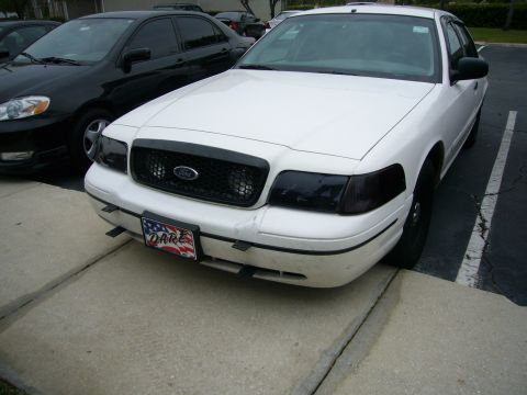 2000 Ford Crown Victoria - Front view of a white 2000 Ford Crown Victoria, parked in a lot. Another car is visible to the left.
