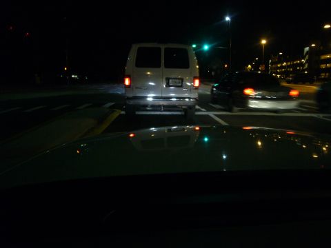 2000 Ford Crown Victoria - A white van is seen from behind at a traffic light at night.