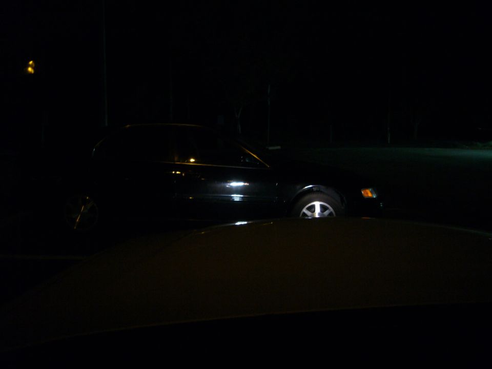 Side view of a black sedan at night