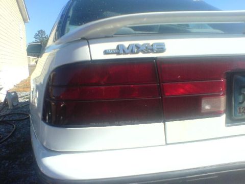 1996 Ford Probe - The rear of a white Mazda MX-6 is visible, its distinctive taillights and spoiler.