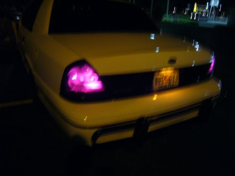 2000 Ford Crown Victoria - Rear view of a yellow 2000 Ford Crown Victoria, showing its distinctive tail lights and license plate.