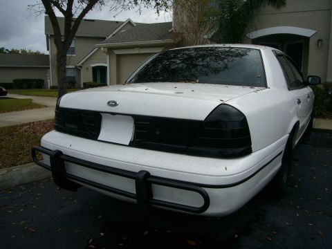 2000 Ford Crown Victoria - This white Ford Crown Victoria has a black grille and tinted tail lights, parked in a driveway.