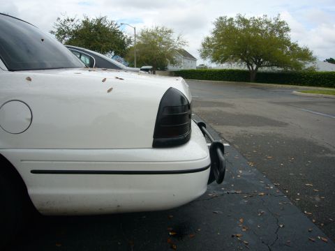 2000 Ford Crown Victoria - Rear view of a white sedan with tinted tail lights and a black bumper guard.
