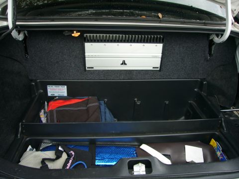 2000 Ford Crown Victoria - Trunk interior with aftermarket amplifier and police trunk organizer holding various items.