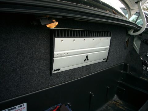 2000 Ford Crown Victoria - A car audio amplifier is installed in the trunk, with a small light illuminating the area.