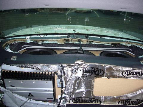 2000 Ford Crown Victoria - Car audio install viewed from inside the trunk looking up at the rear window, with three subwoofers mounted through the rear deck and a sil…