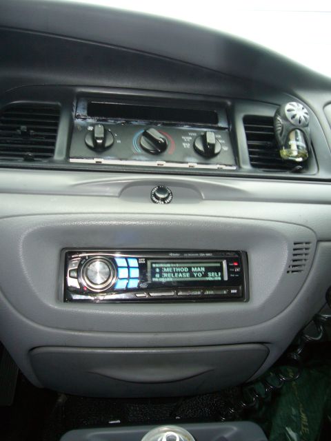 2000 Ford Crown Victoria - Aftermarket stereo installed in a car's dashboard, displaying song information.